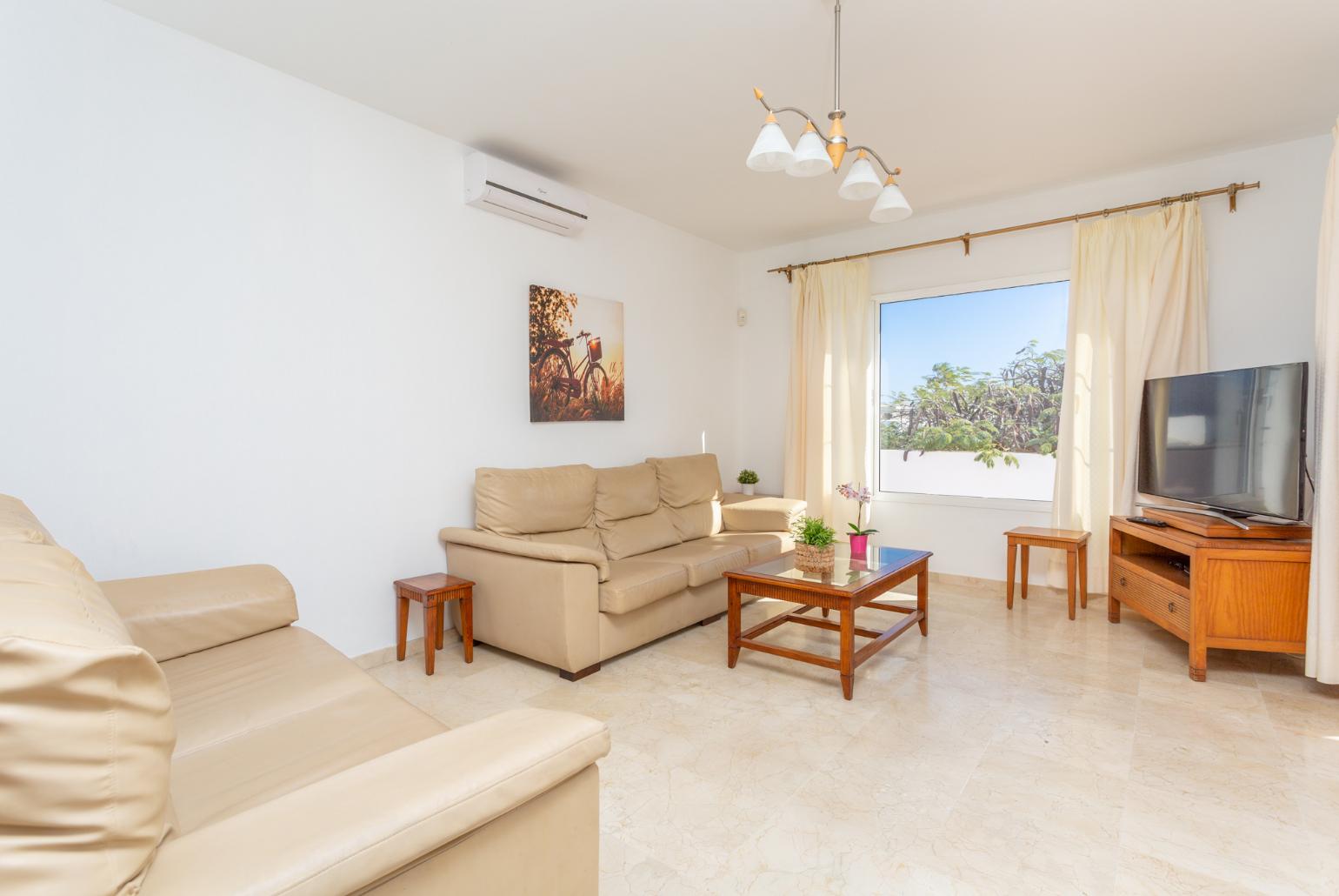 Living room with sofas, A/C, WiFi internet, satellite TV, and terrace access