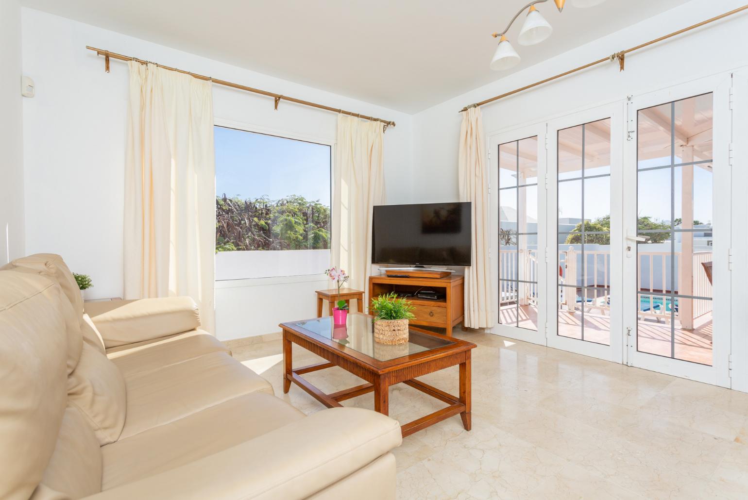 Living room with sofas, A/C, WiFi internet, satellite TV, and terrace access