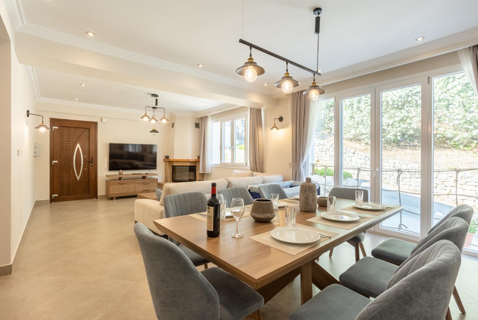 Open-plan living room with sofas, dining area, kitchen, ornamental fireplace, WiFi internet, and satellite TV