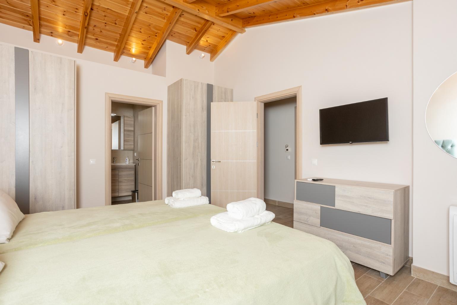 Twin bedroom with en suite bathroom, A/C, TV, and terrace access