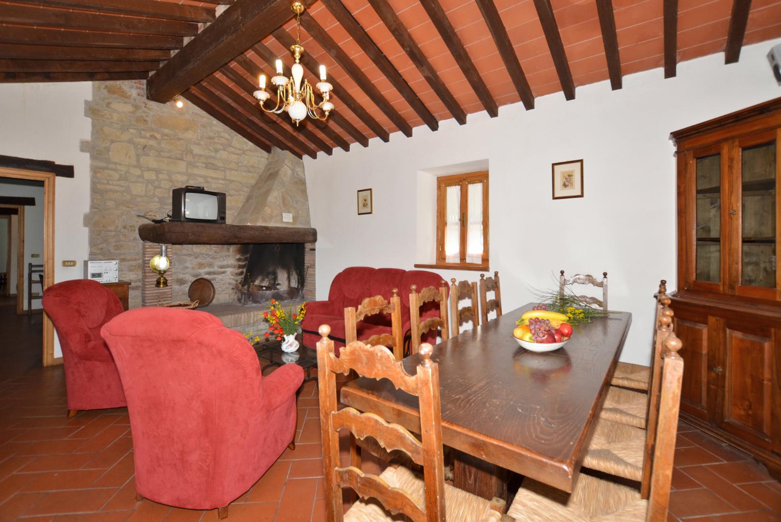 Living room with sofas, dining area, ornamental fireplace, and satellite TV