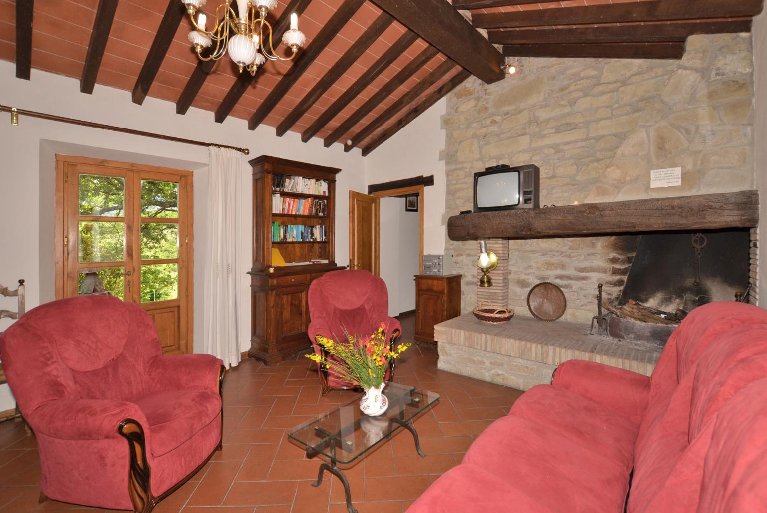 Living room with sofas, dining area, ornamental fireplace, and satellite TV