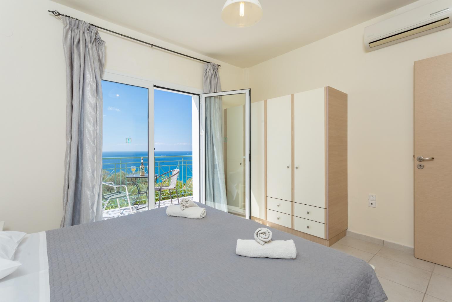 Double bedroom with en suite bathroom, A/C, and upper terrace access with panoramic sea views