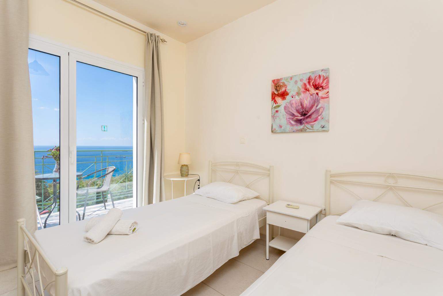 Twin bedroom with en suite bathroom, A/C, and upper terrace access with panoramic sea views