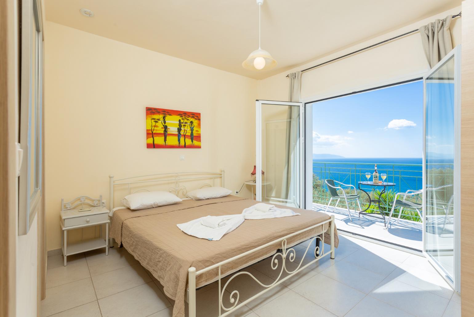 Double bedroom with en suite bathroom, A/C, and upper terrace access with panoramic sea views