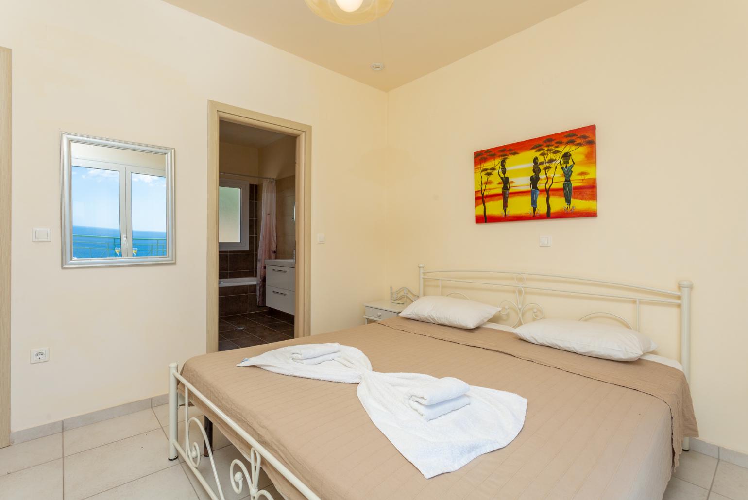 Double bedroom with en suite bathroom, A/C, and upper terrace access with panoramic sea views