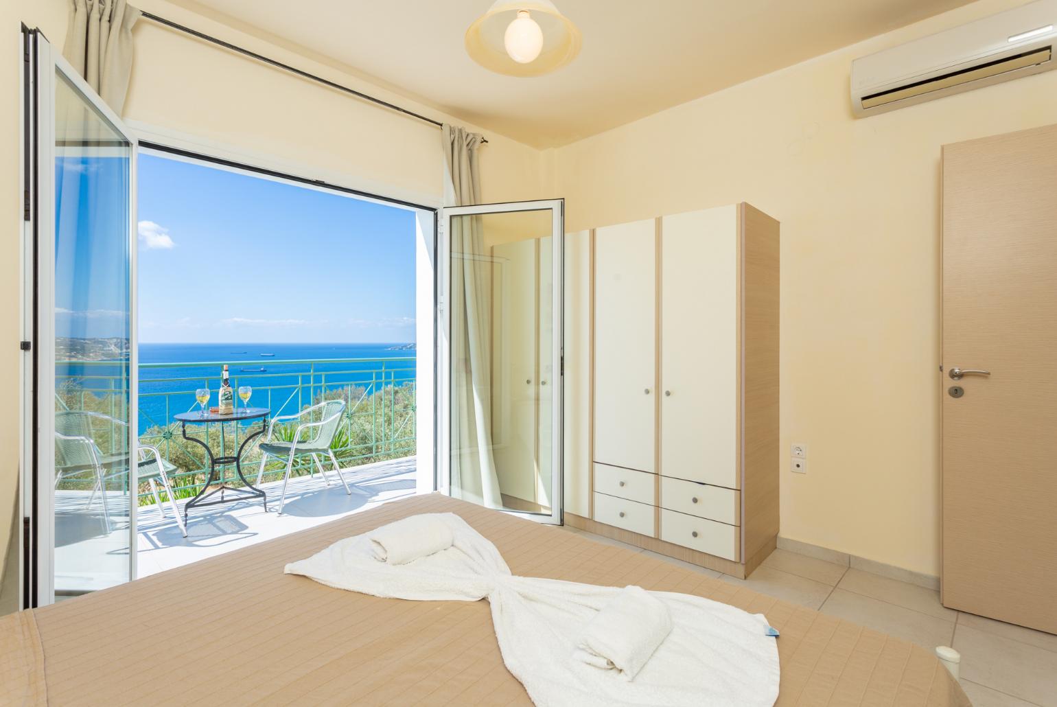 Double bedroom with en suite bathroom, A/C, and upper terrace access with panoramic sea views