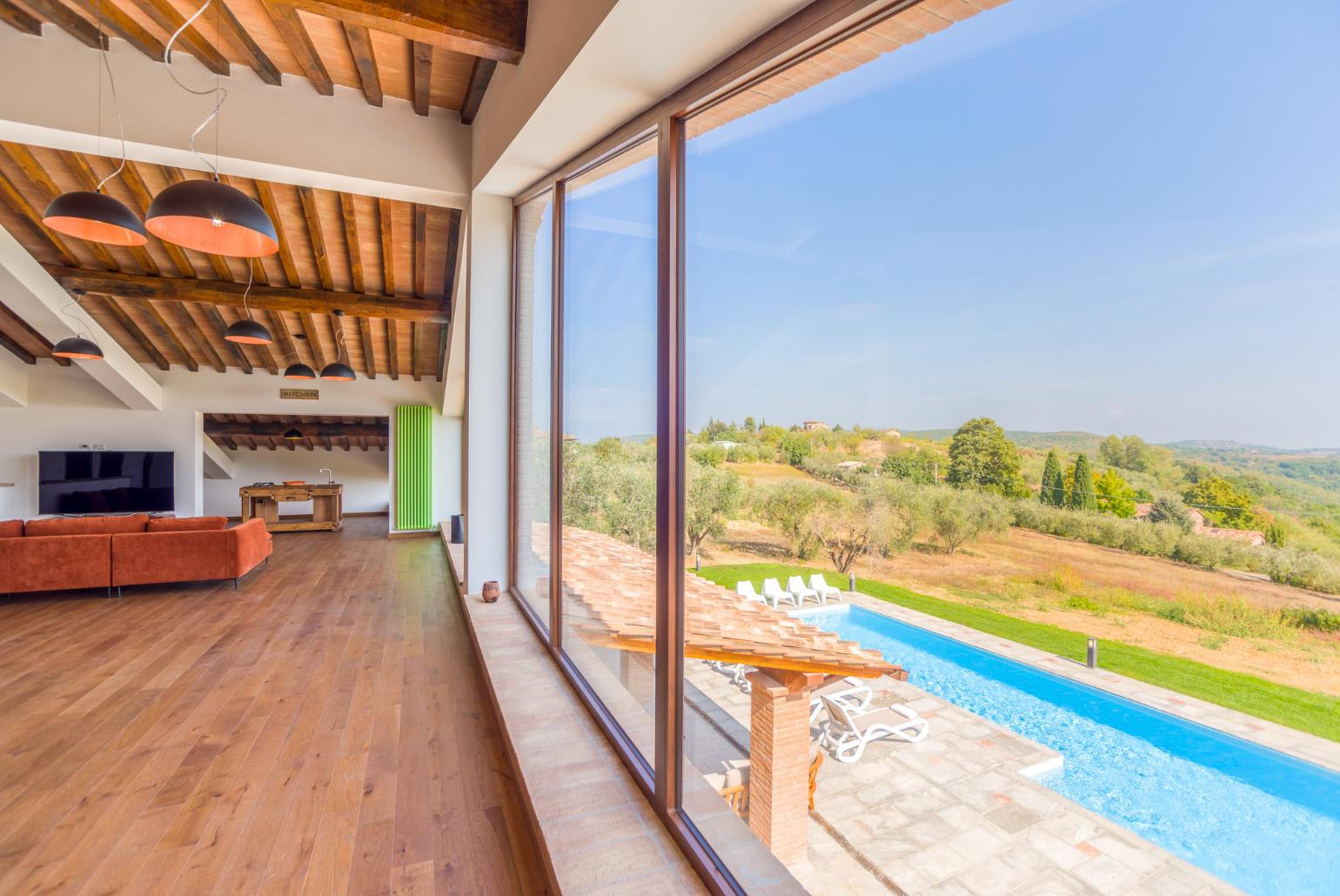 Living room on first floor with sofas, kitchenette, satellite TV, and panoramic views