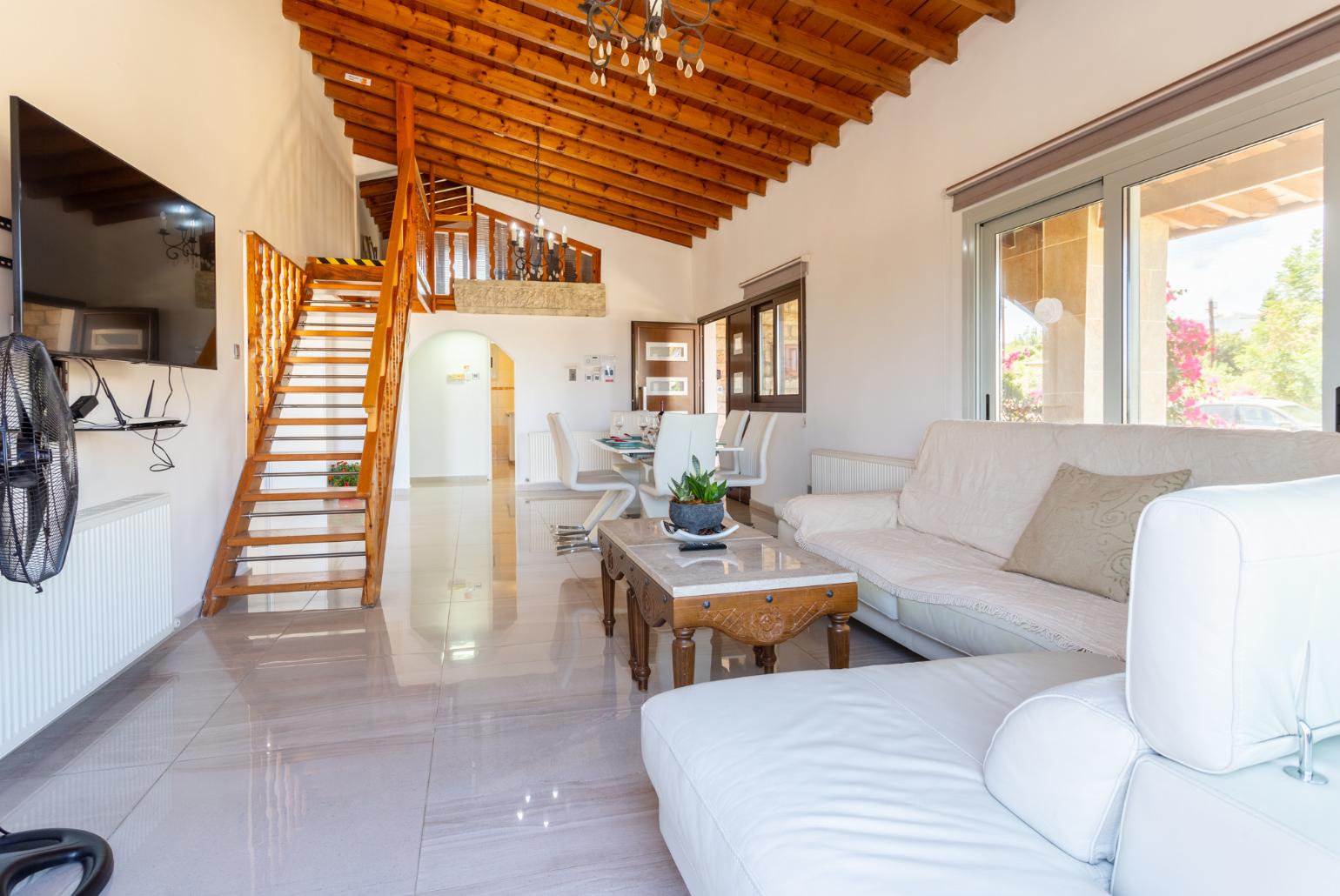 Open-plan living room with sofas, dining area, kitchen, ornamental fireplace, mezzanine, WiFi internet, and TV