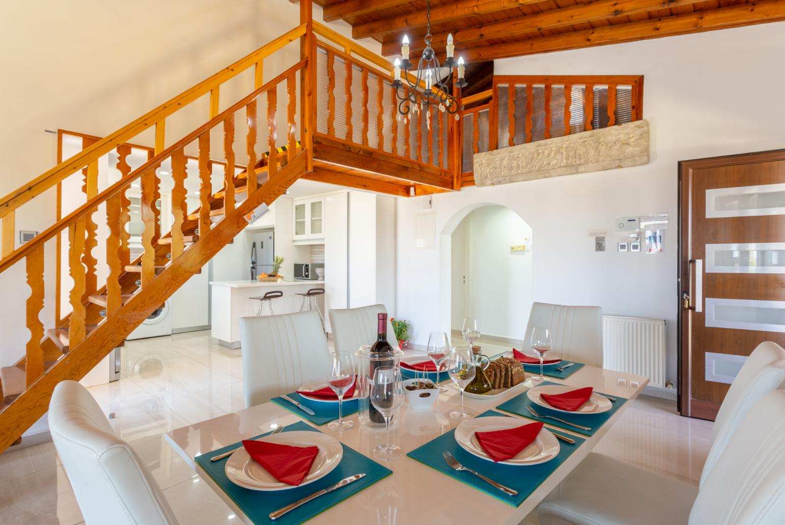 Open-plan living room with sofas, dining area, kitchen, ornamental fireplace, mezzanine, WiFi internet, and TV