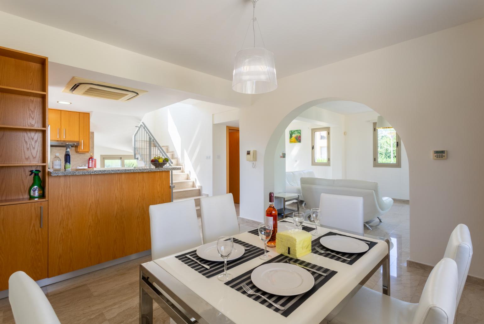 Open-plan living room with sofas, dining area, kitchen, ornamental fireplace, A/C, WiFi internet, and TV 