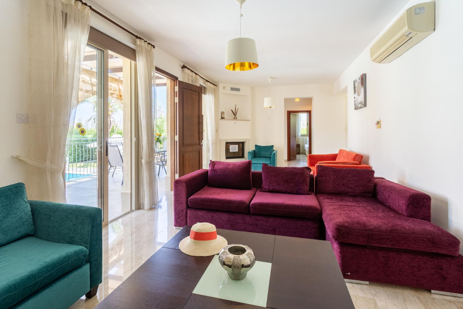 Living room with sofas, ornamental fireplace, A/C, WiFi internet, and TV