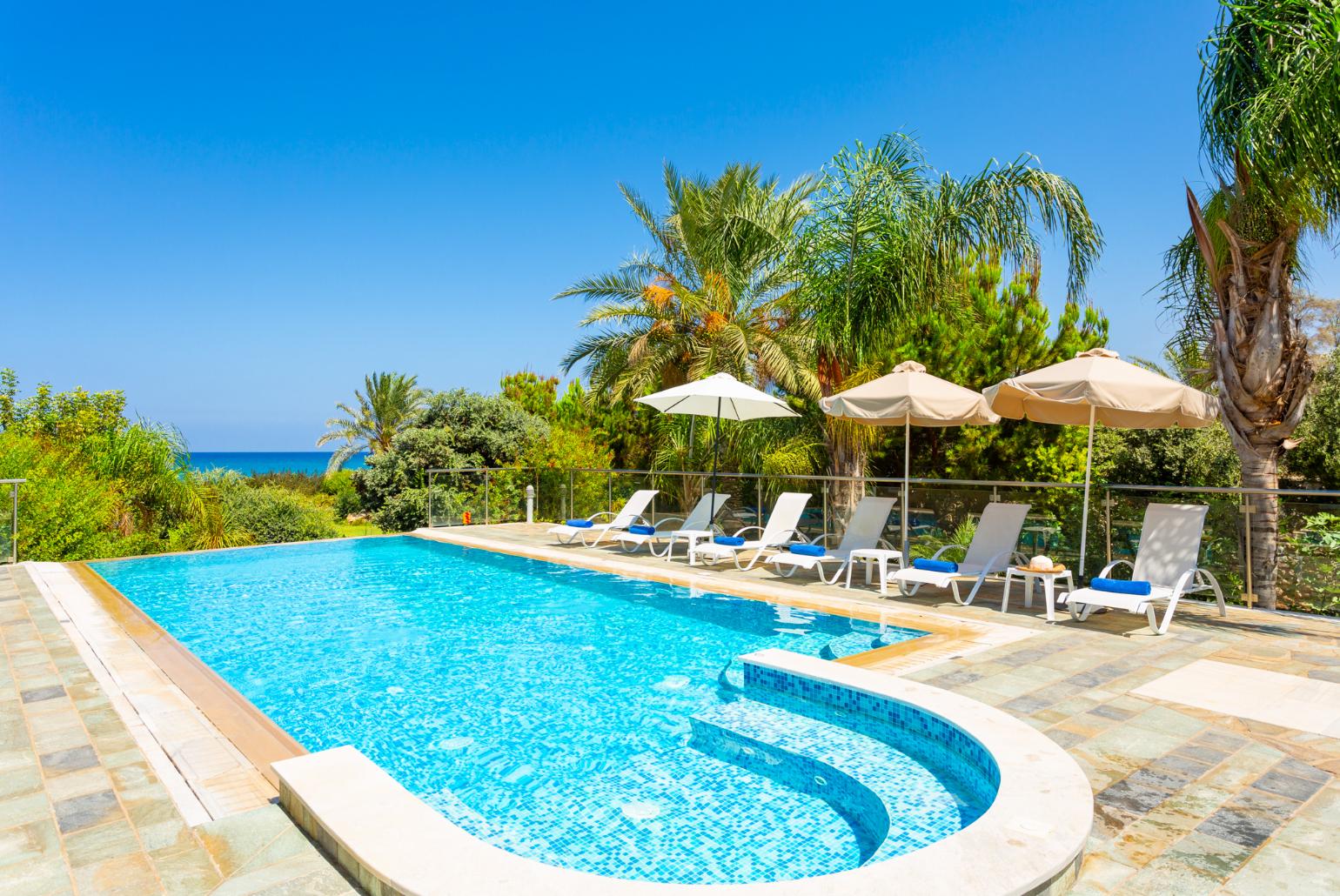 Private infinity pool, terrace, and garden with sea views