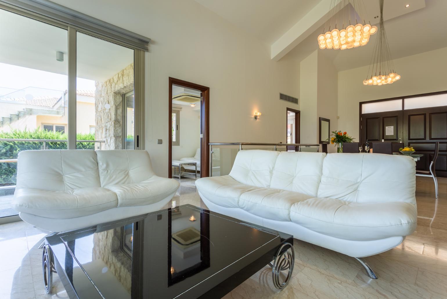 Open-plan living room with sofas, dining area, kitchen, ornamental fireplace, A/C, WiFi internet, satellite TV, and sea views