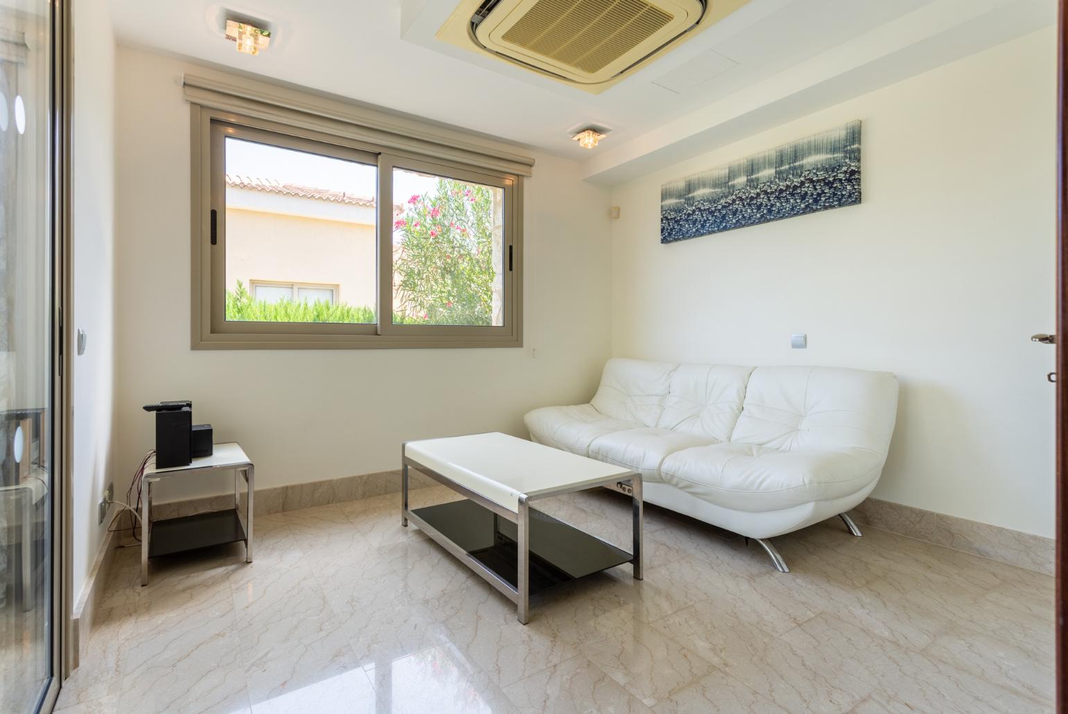 Open-plan living room with sofas, dining area, kitchen, ornamental fireplace, A/C, WiFi internet, satellite TV, and sea views