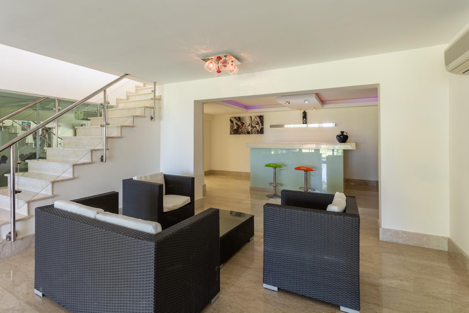 Living room on lower level with sofas, bar, jacuzzi, gym, and A/C