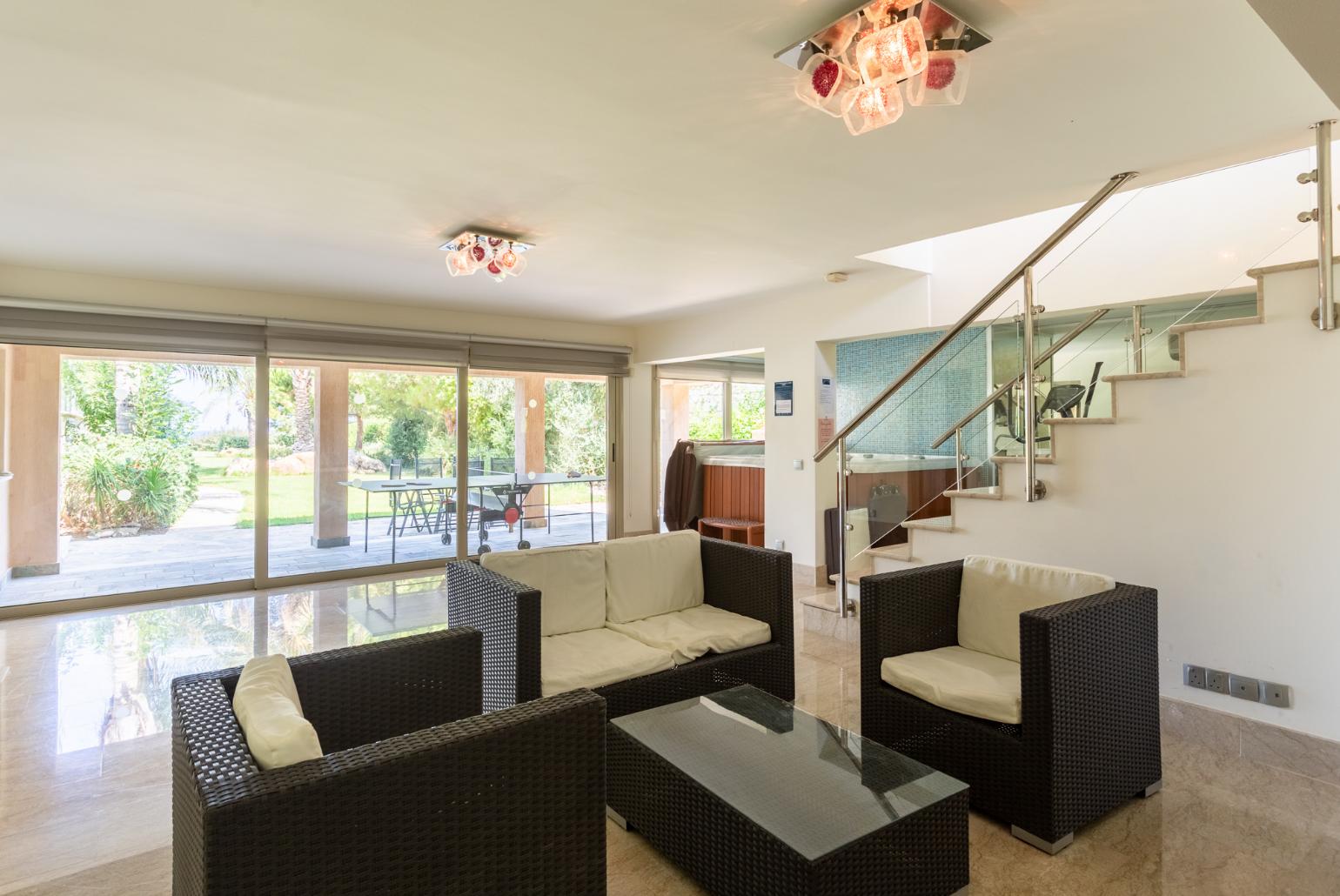 Living room on lower level with sofas, bar, jacuzzi, gym, and A/C
