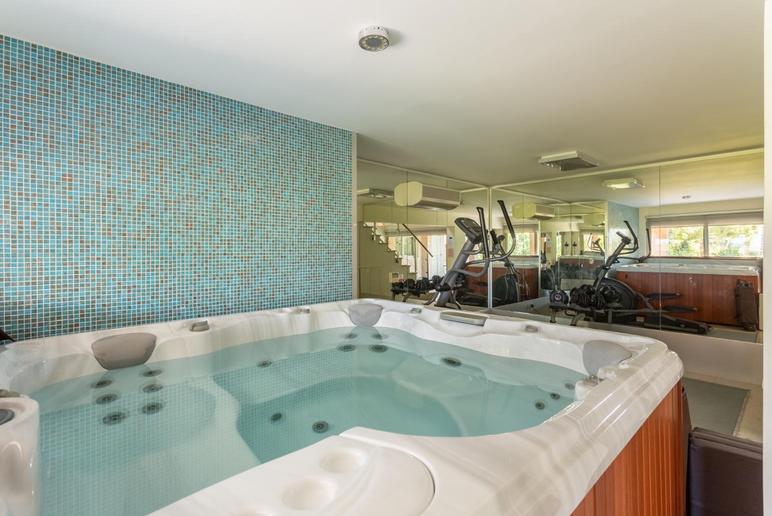 Living room on lower level with sofas, bar, jacuzzi, gym, and A/C