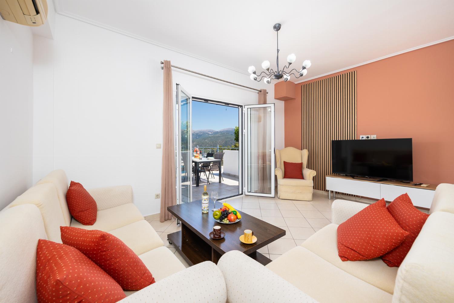 Open-plan living room with sofas, dining area, kitchen, A/C, WiFi internet, and satellite TV