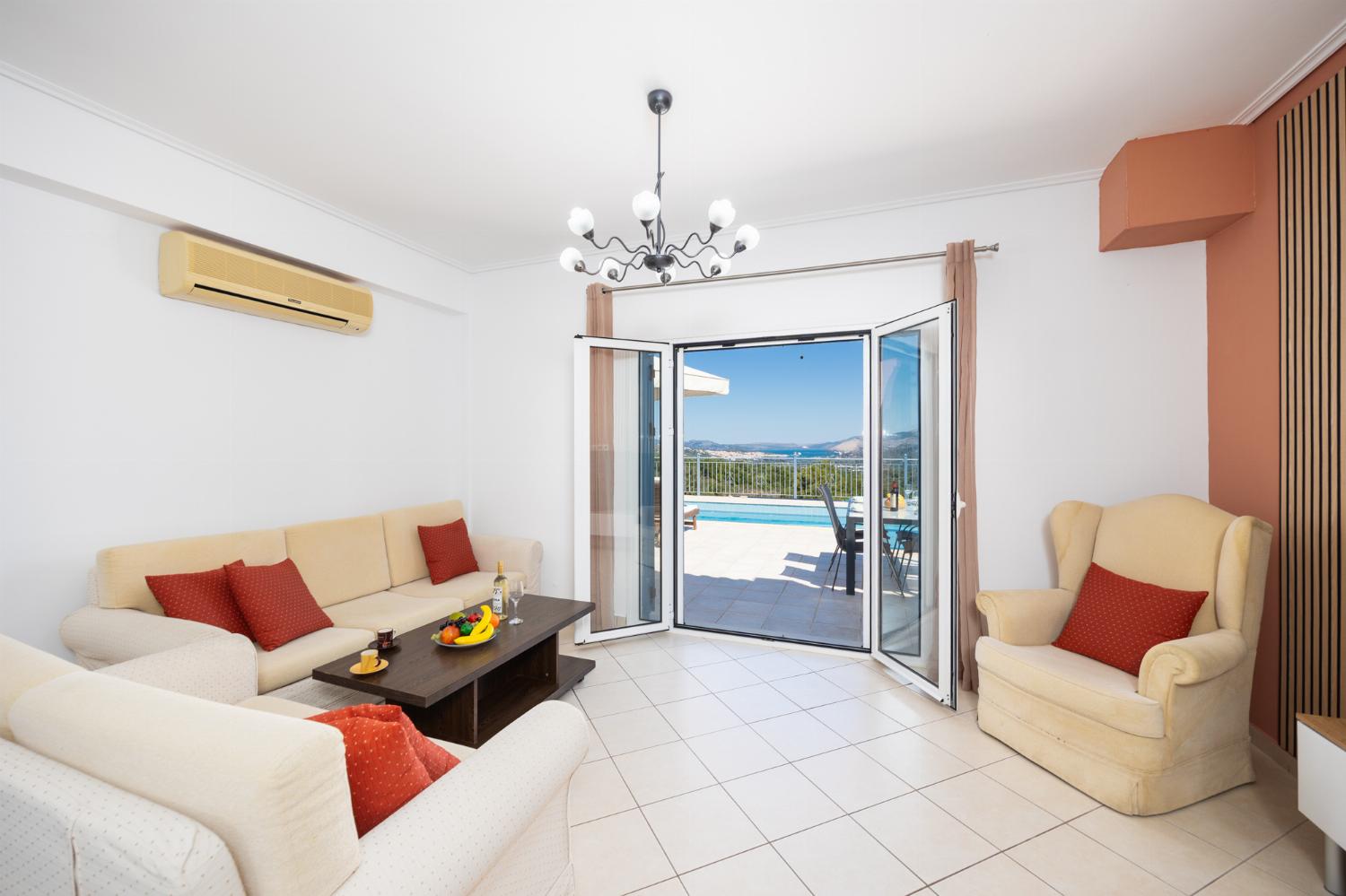 Open-plan living room with sofas, dining area, kitchen, A/C, WiFi internet, and satellite TV