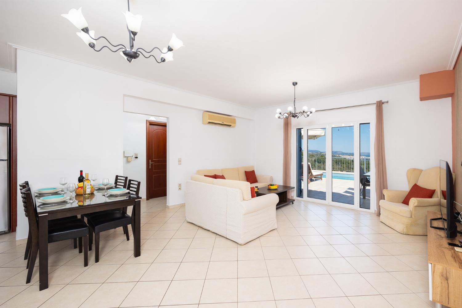 Open-plan living room with sofas, dining area, kitchen, A/C, WiFi internet, and satellite TV