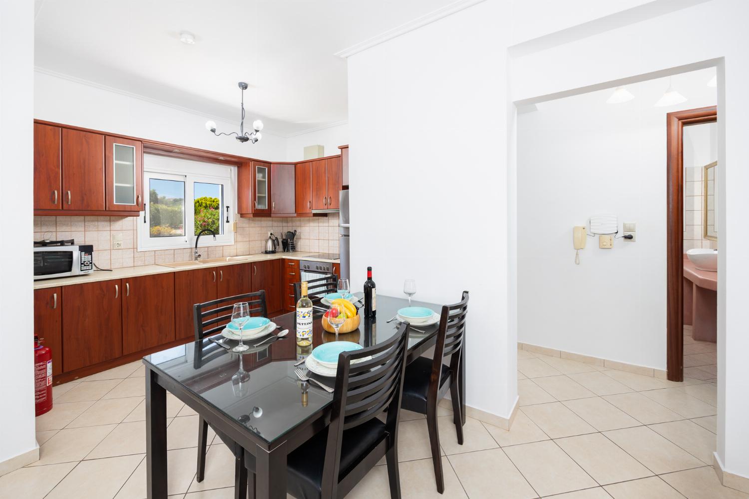 Open-plan living room with sofas, dining area, kitchen, A/C, WiFi internet, and satellite TV