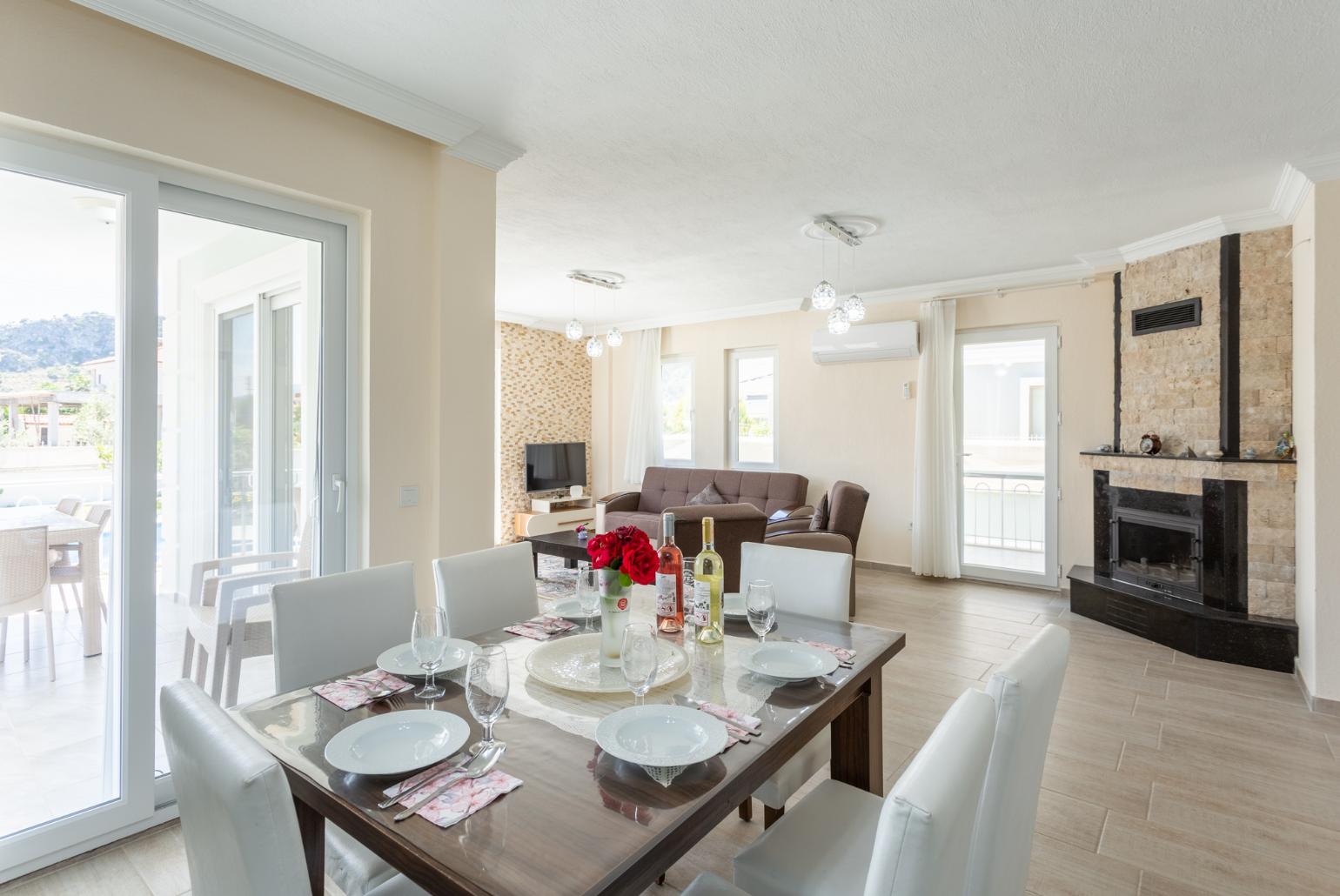 Open-plan living room with sofas, dining area, kitchen, ornamental fireplace, A/C, WiFi internet, satellite TV, and terrace access