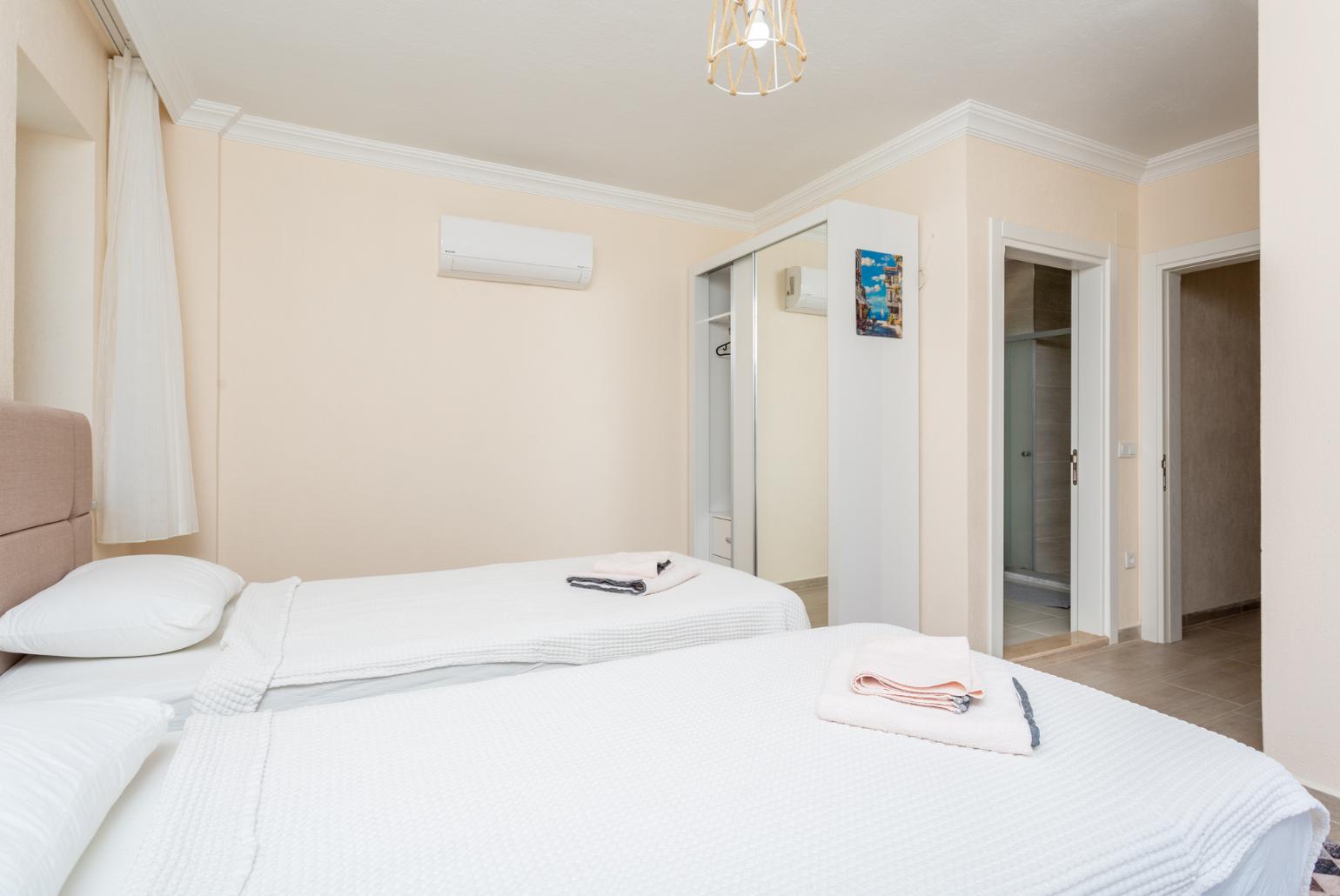 Twin bedroom with en suite bathroom, A/C, and balcony access