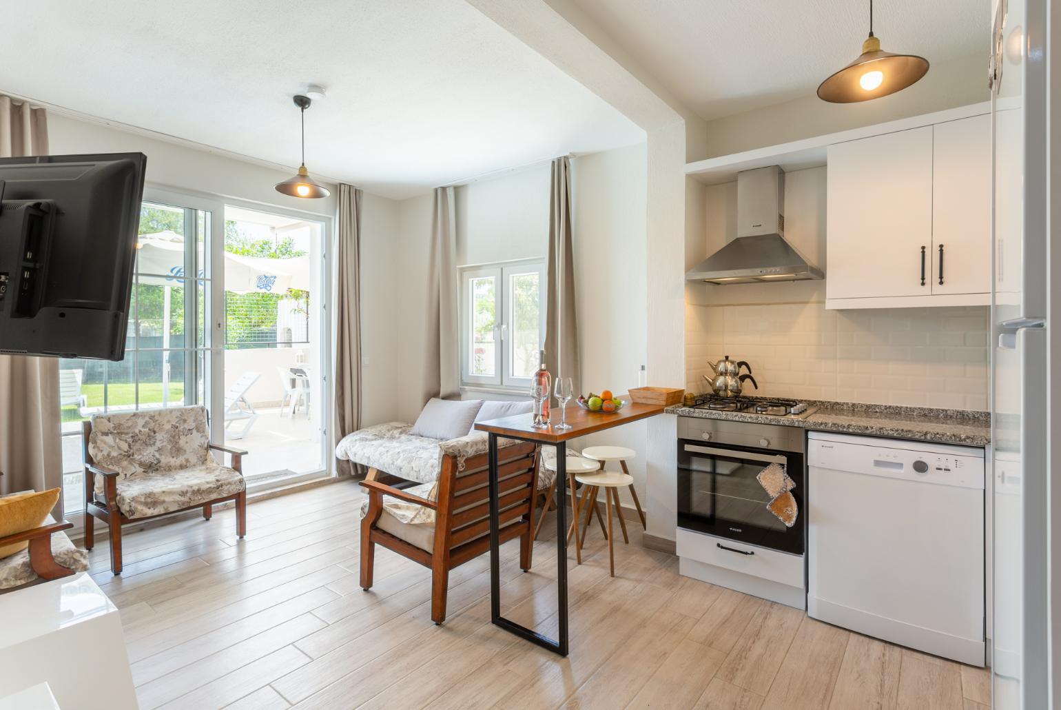 Open-plan living room with sofas, kitchen, A/C, WiFi internet, satellite TV, and pool terrace access