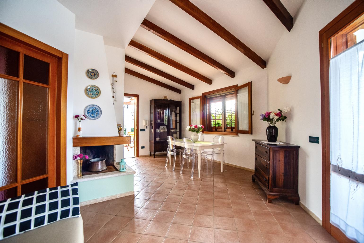 Living room with sofa, dining area, ornamental fireplace, A/C, WiFi internet, and satellite TV