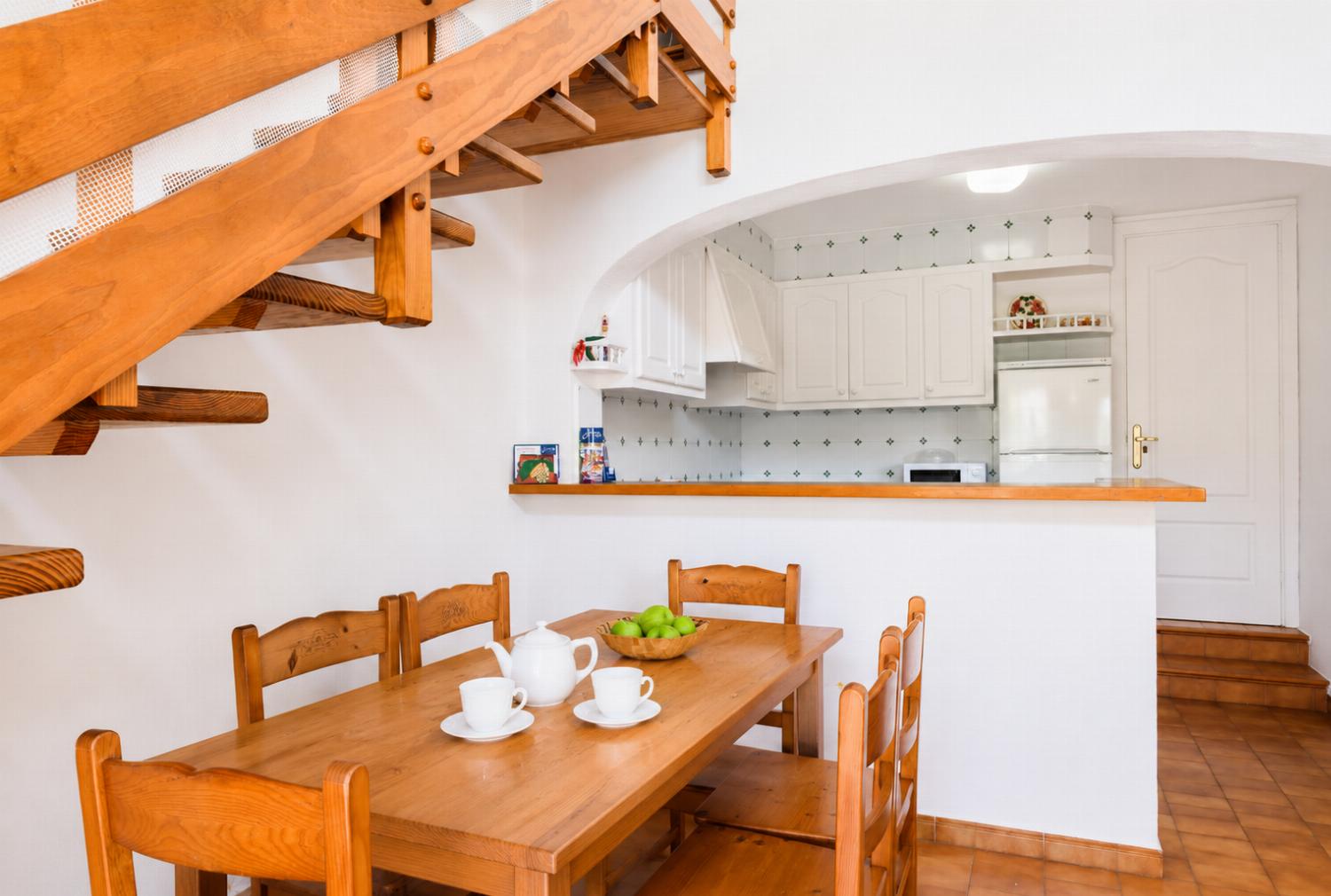 Open-plan living room with sofas, dining area, kitchen, ornamental fireplace, A/C, WiFi internet, and satellite TV