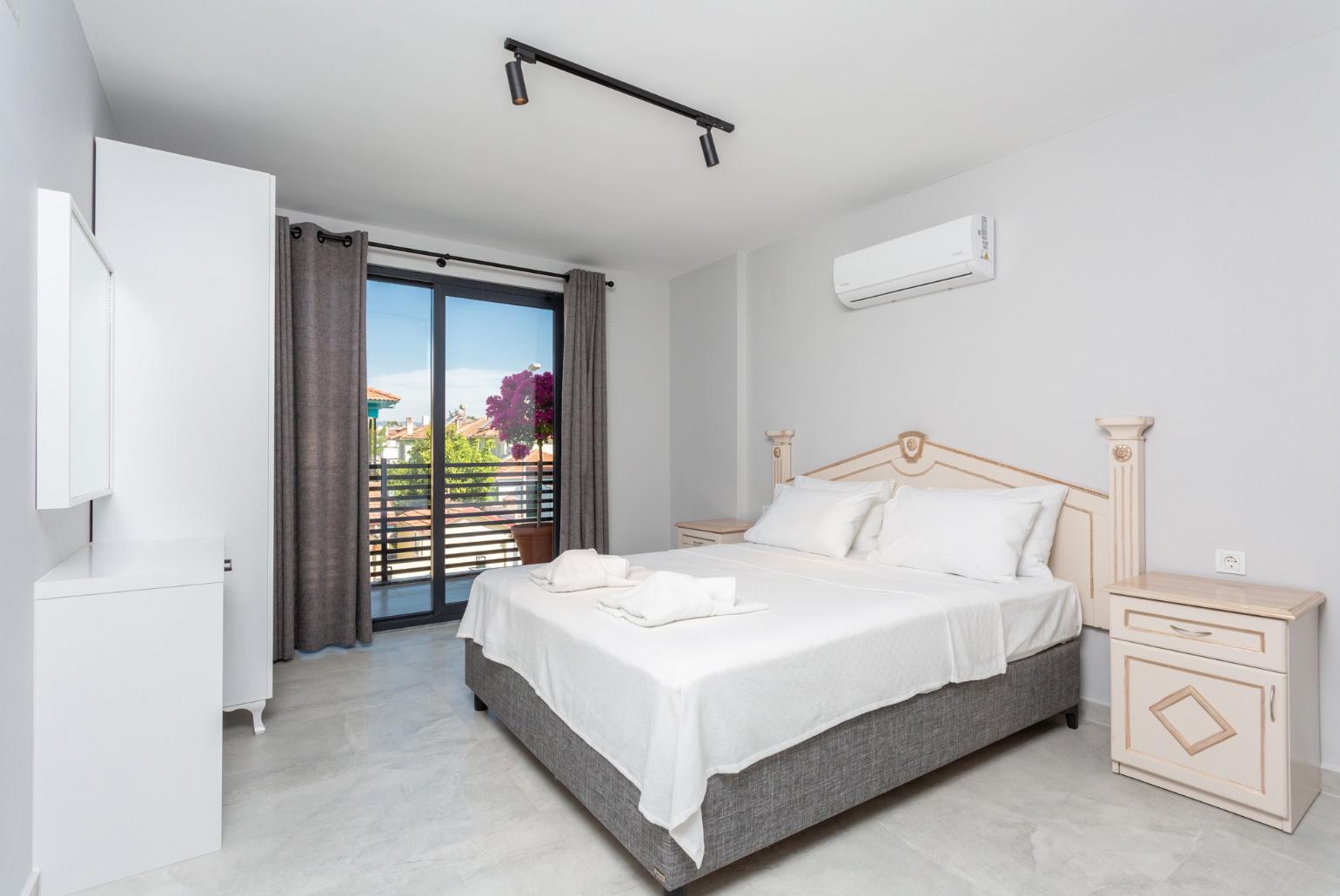 Double bedroom with en suite bathroom, A/C, and balcony access