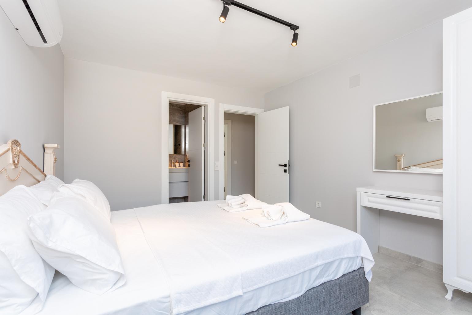 Double bedroom with en suite bathroom, A/C, and balcony access