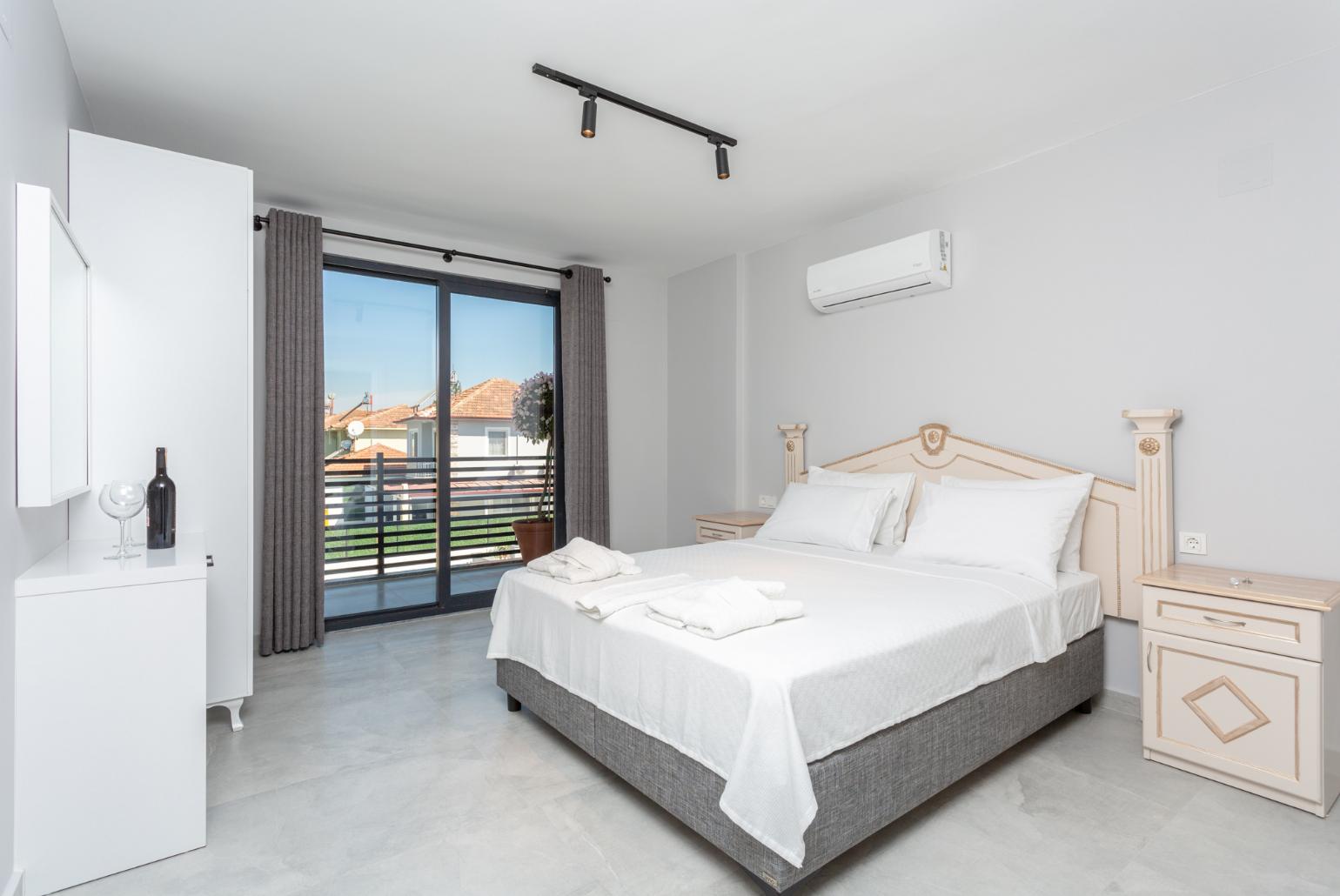 Double bedroom with en suite bathroom, A/C, and balcony access