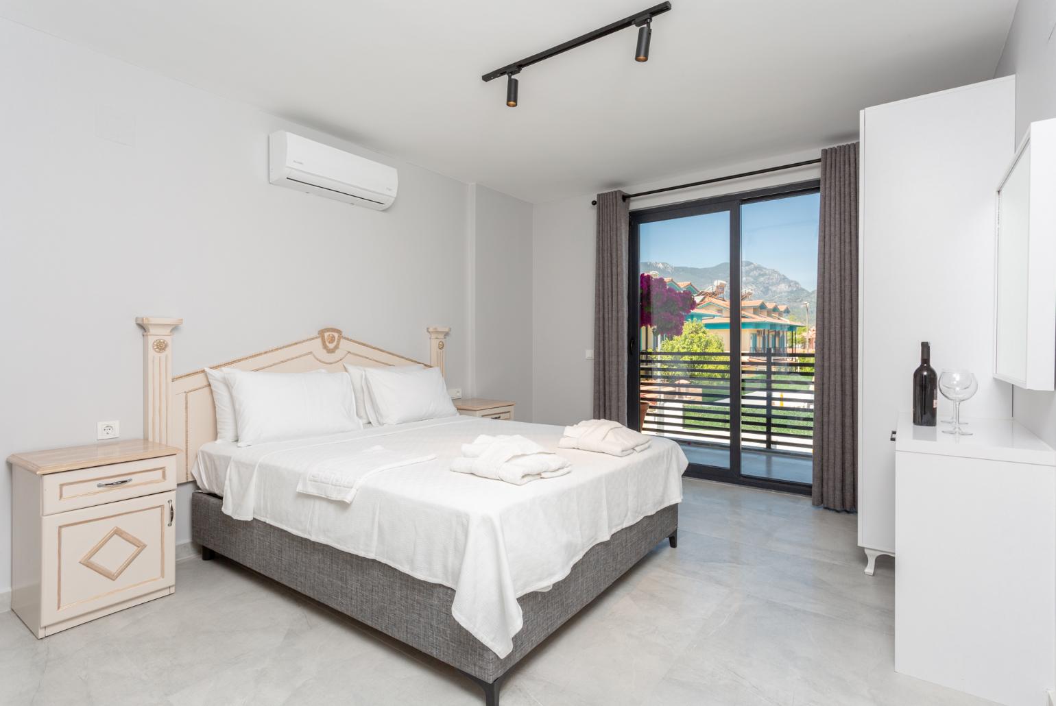 Double bedroom with en suite bathroom, A/C, and balcony access