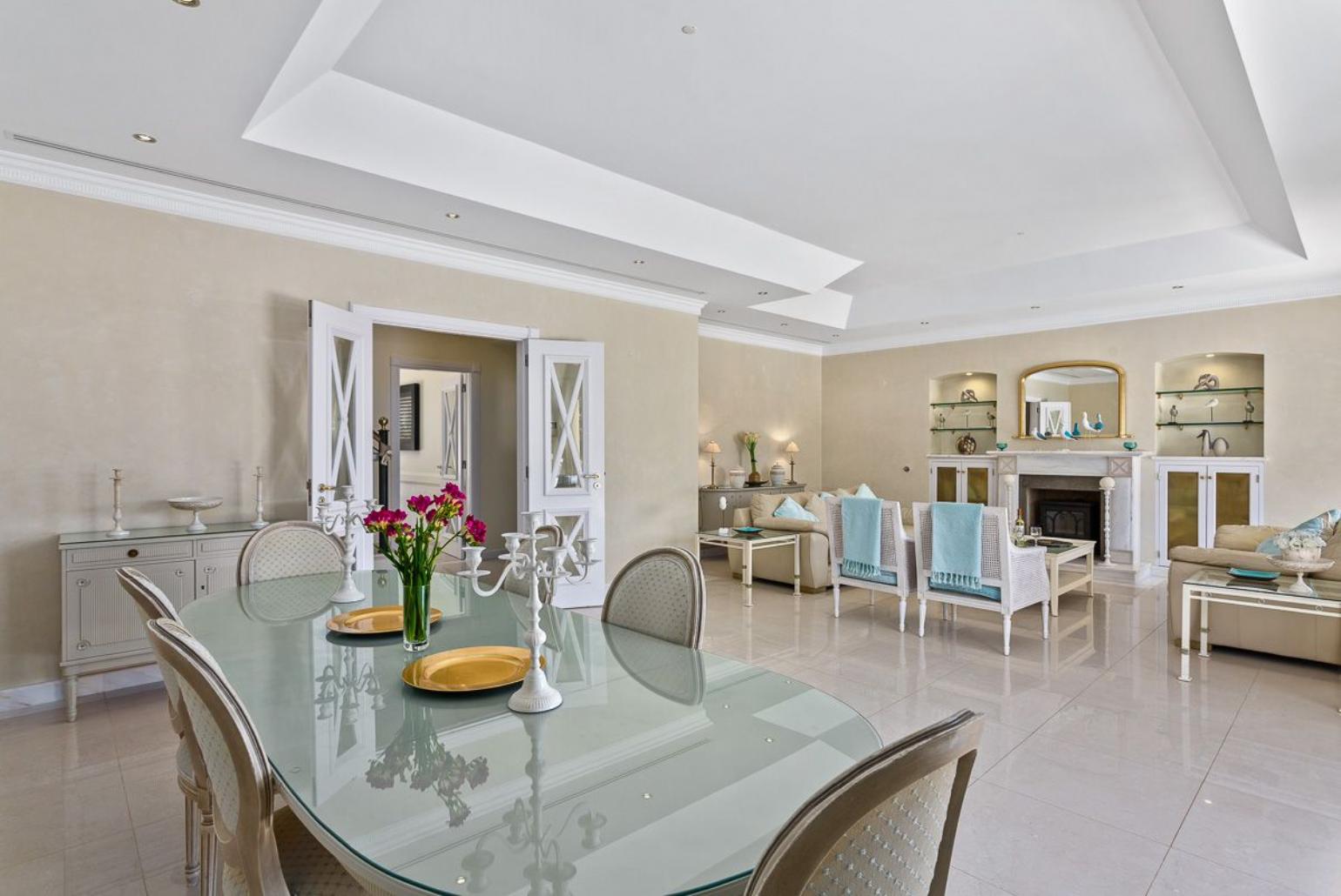 Living room with sofas ,dining area and pool access.  