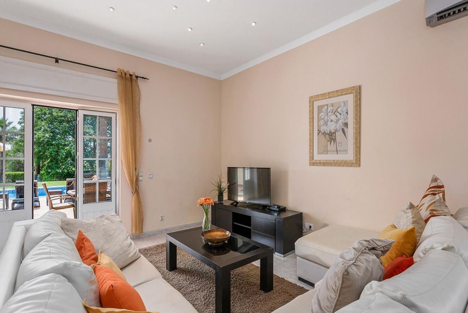 Living room with AC, TV and dining area.