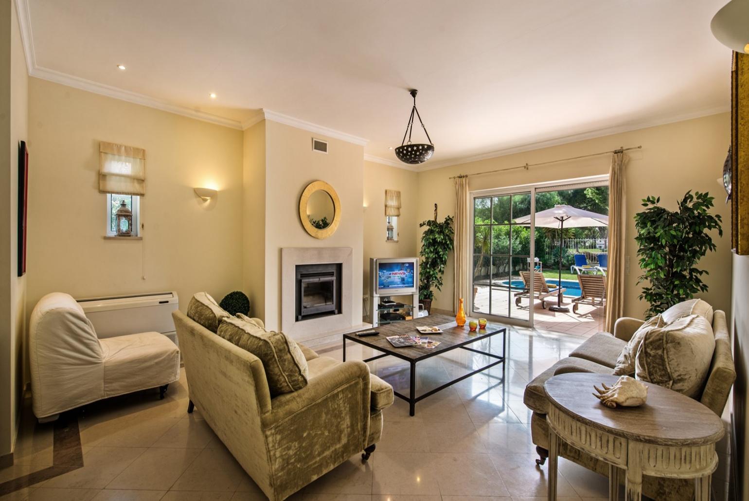 Open -plan living room with TV, pool access,dining area and study area.