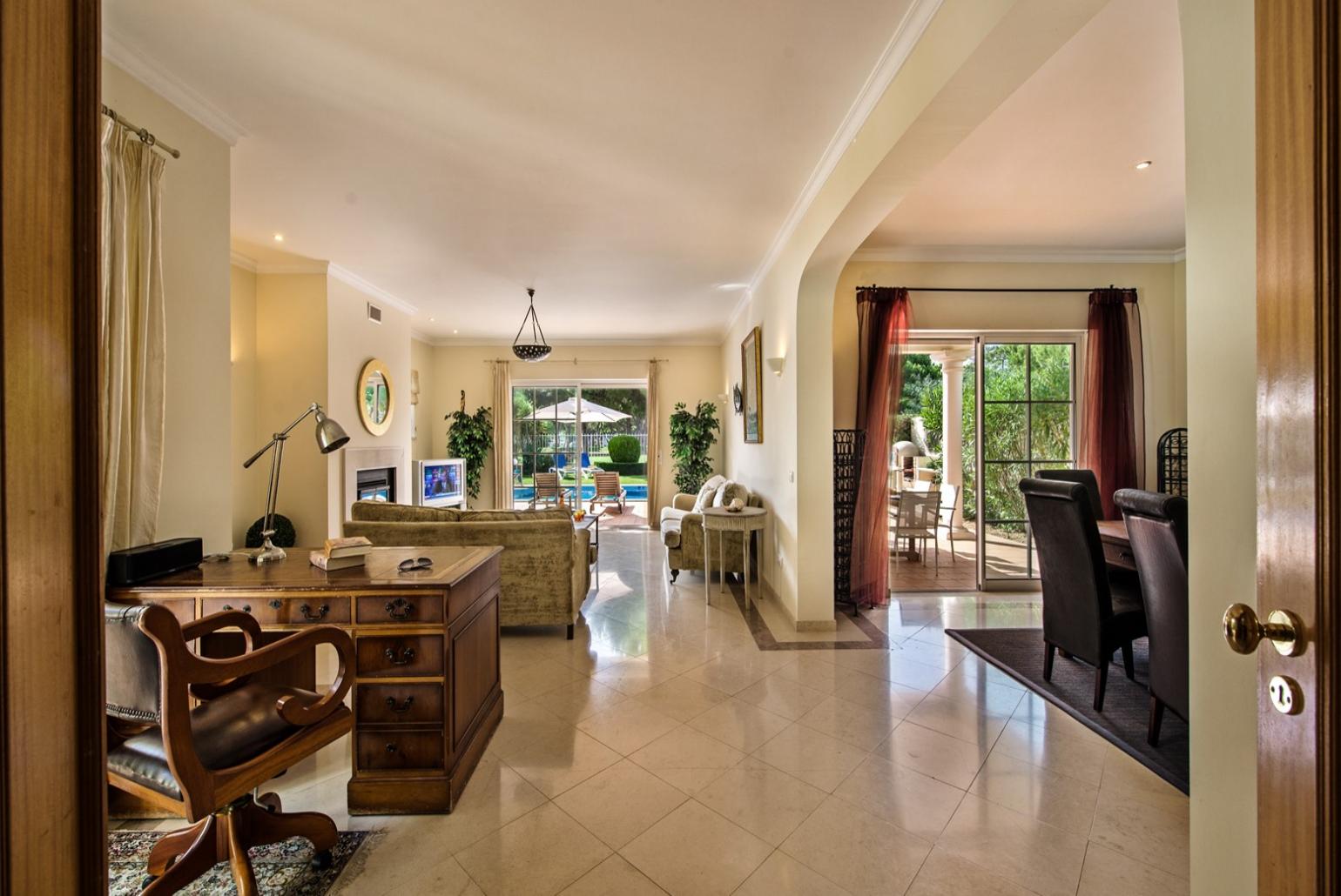 Open -plan living room with TV, pool access,dining area and study area.