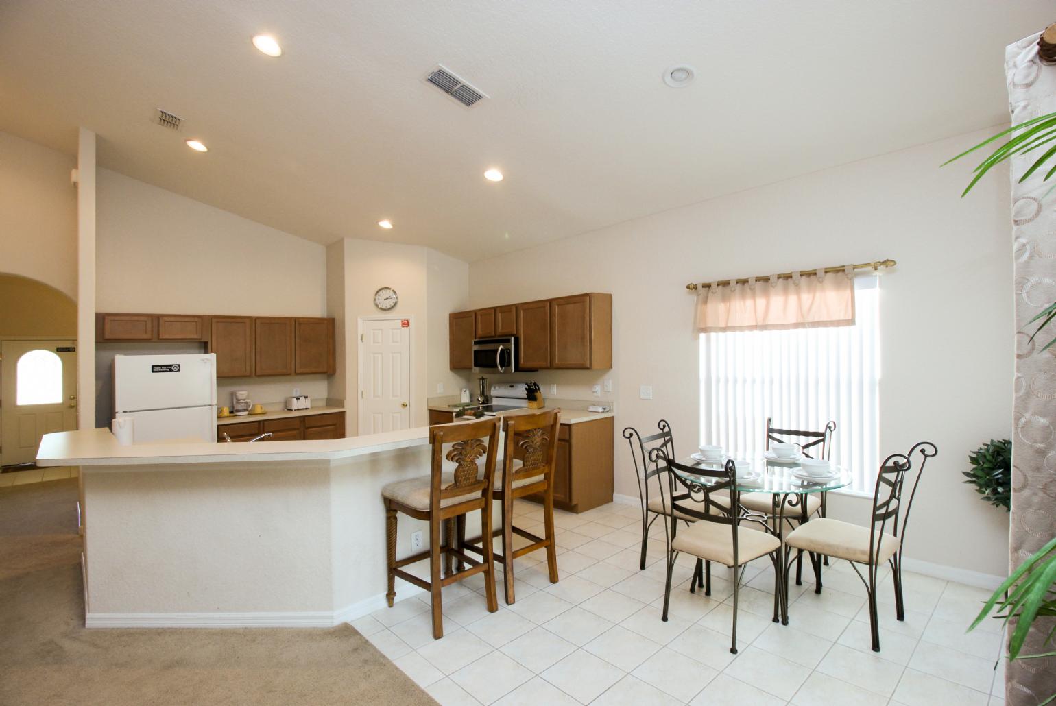 Open-plan living room with equipped kitchen and dining area.