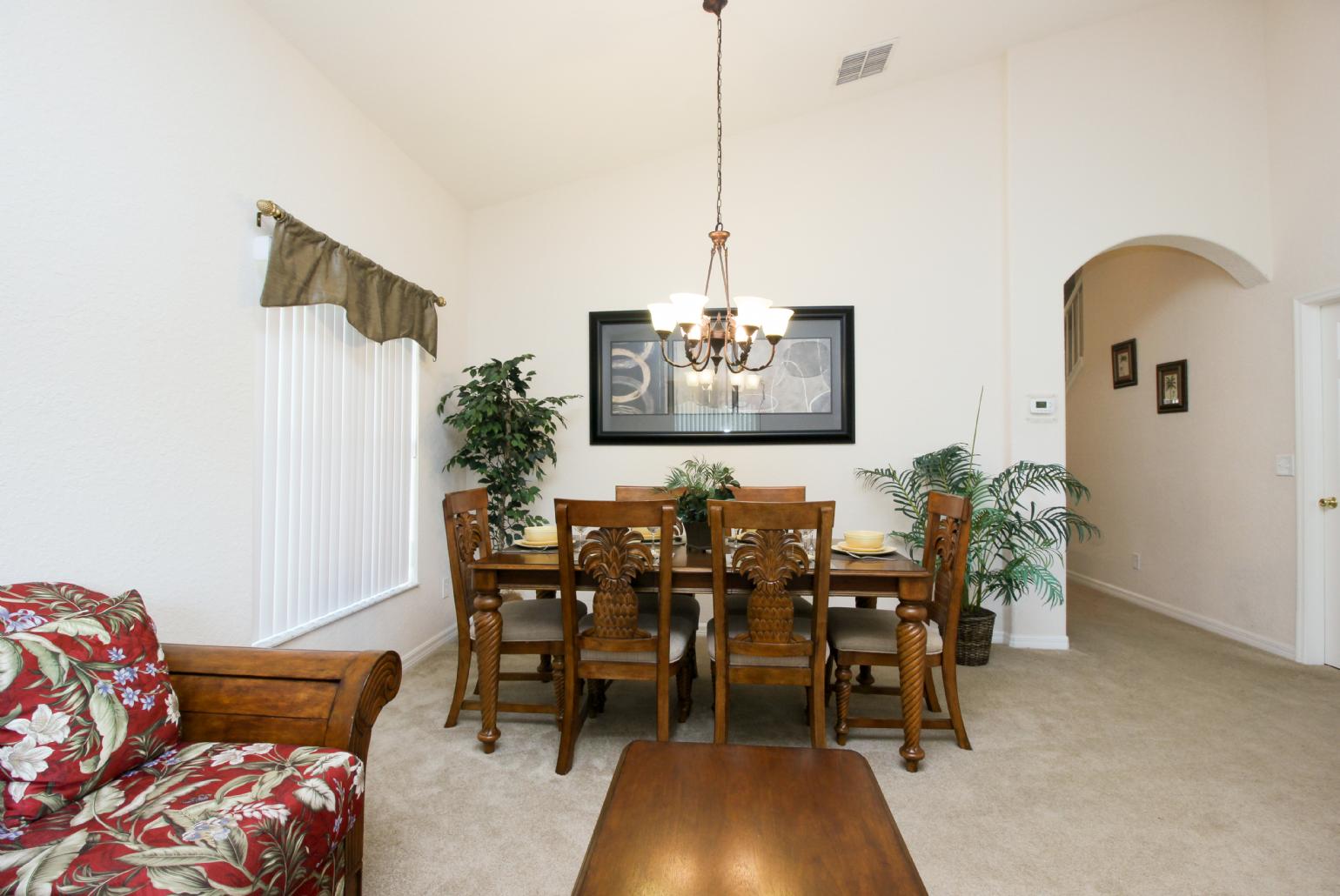 Open-plan living room with equipped kitchen and dining area.