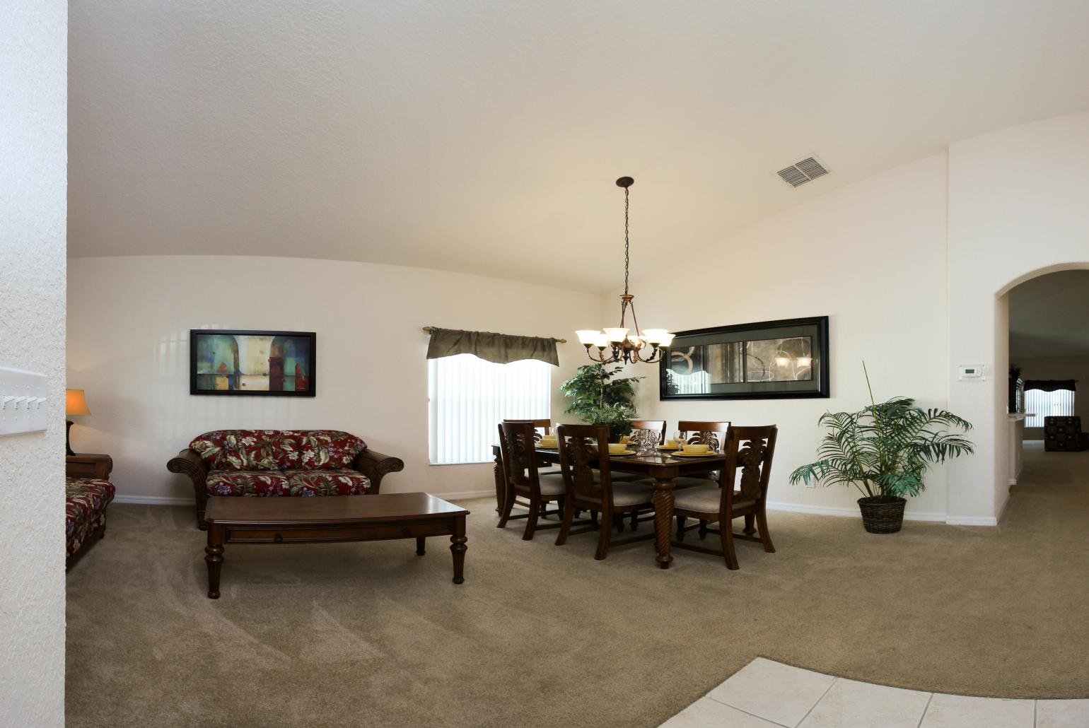 Open-plan living room with equipped kitchen and dining area.