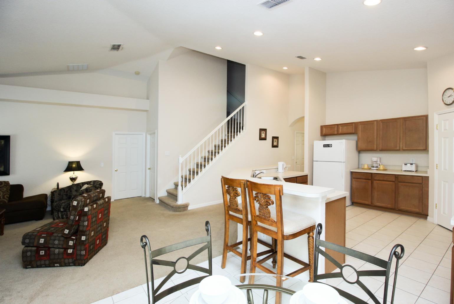 Open-plan living room with equipped kitchen and dining area.