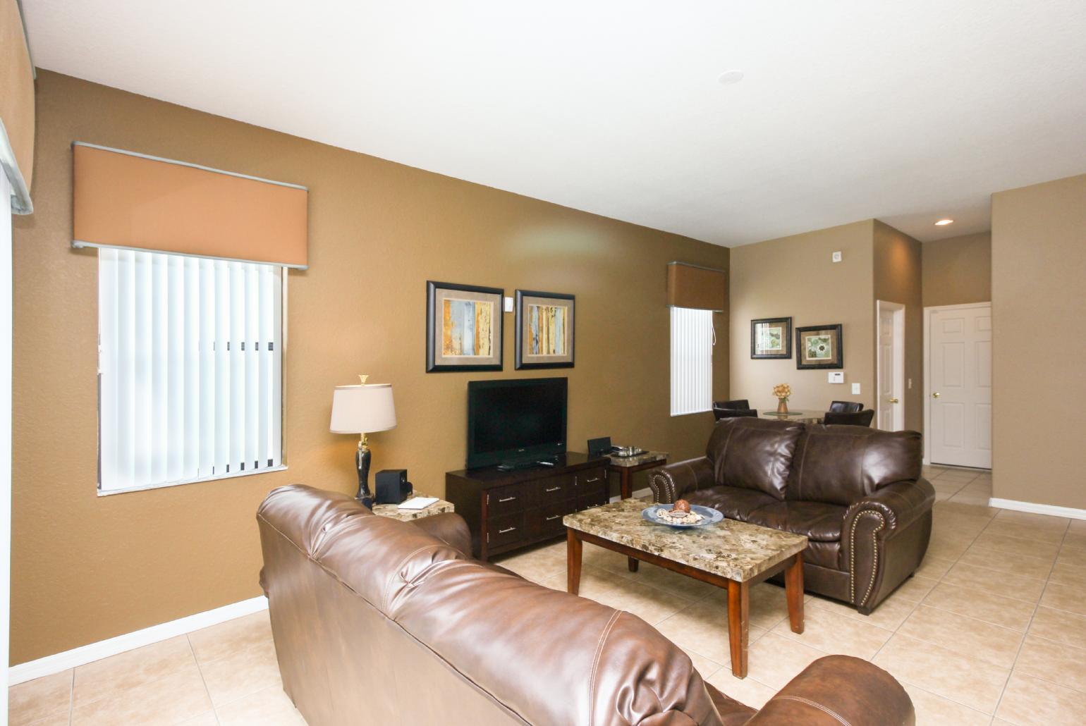 Open-plan living room with equipped kitchen and dining area.