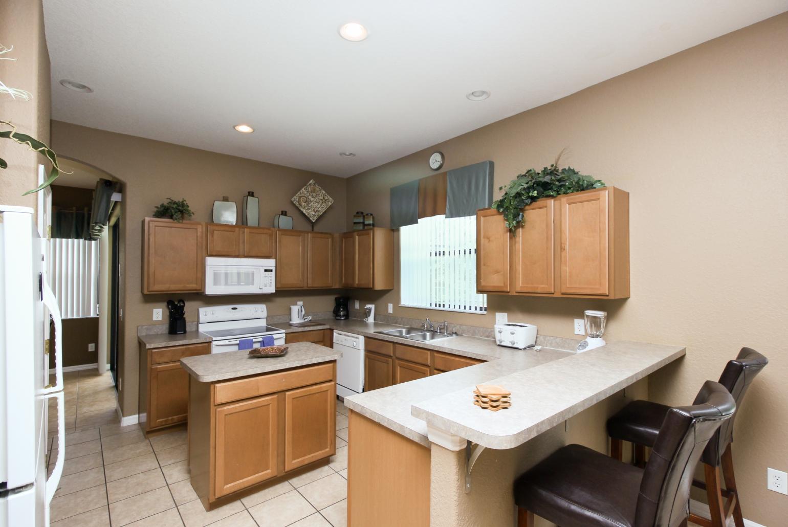 Open-plan living room with equipped kitchen and dining area.