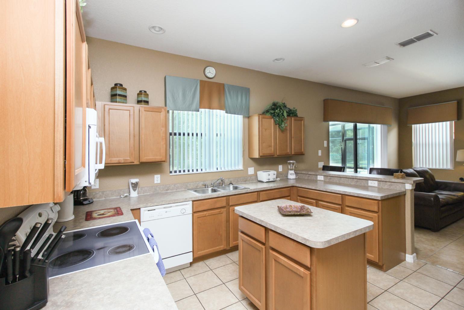 Open-plan living room with equipped kitchen and dining area.