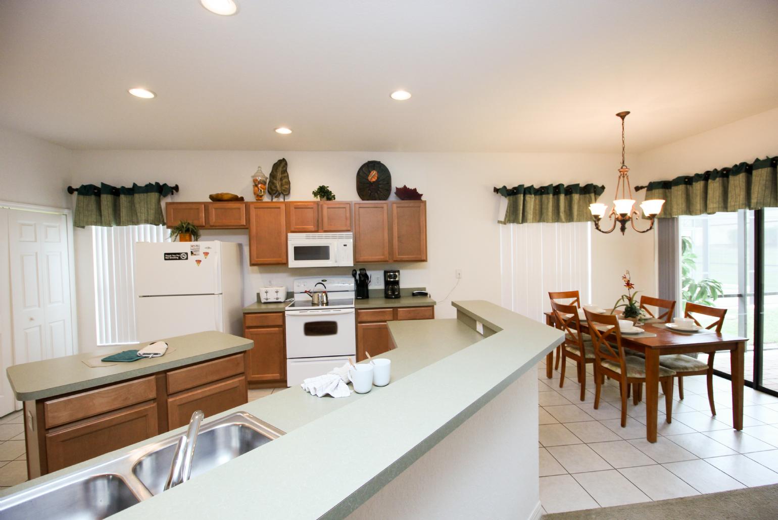 Open-plan living room with equipped kitchen and dining area.