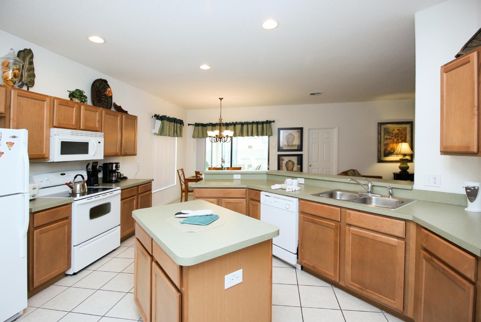 Open-plan living room with equipped kitchen and dining area.