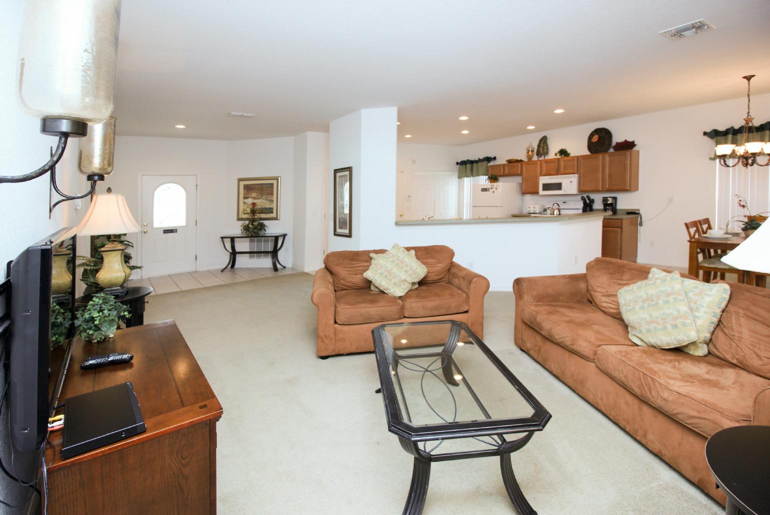 Open-plan living room with equipped kitchen and dining area.