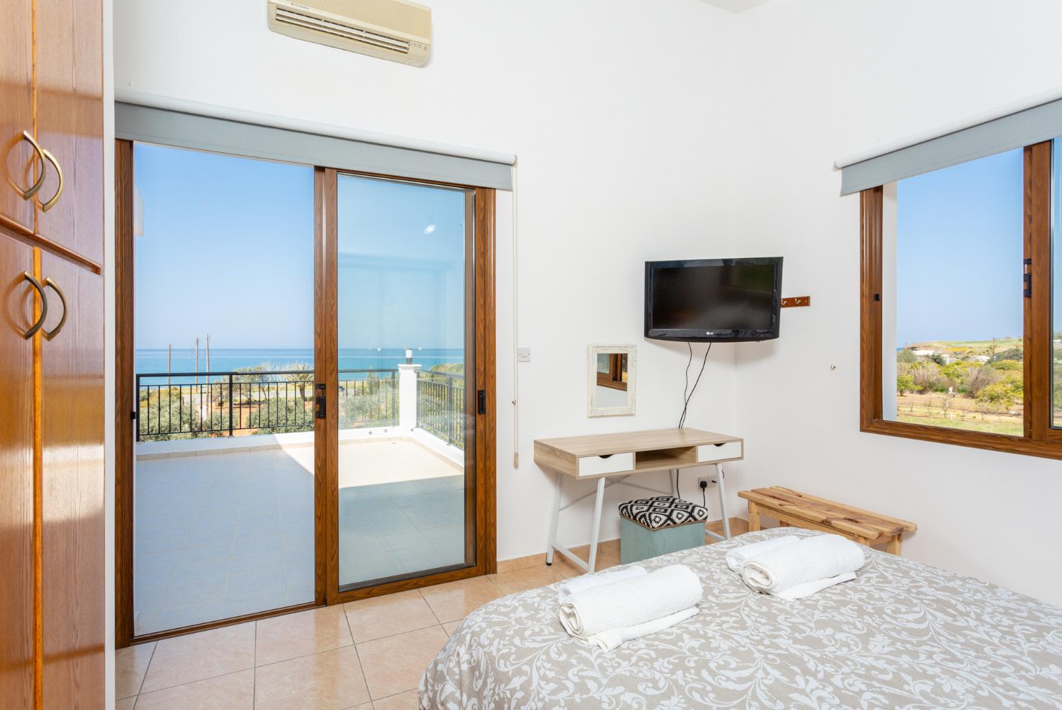 Double bedroom with en suite bathroom, A/C, TV, and upper terrace access with sea views